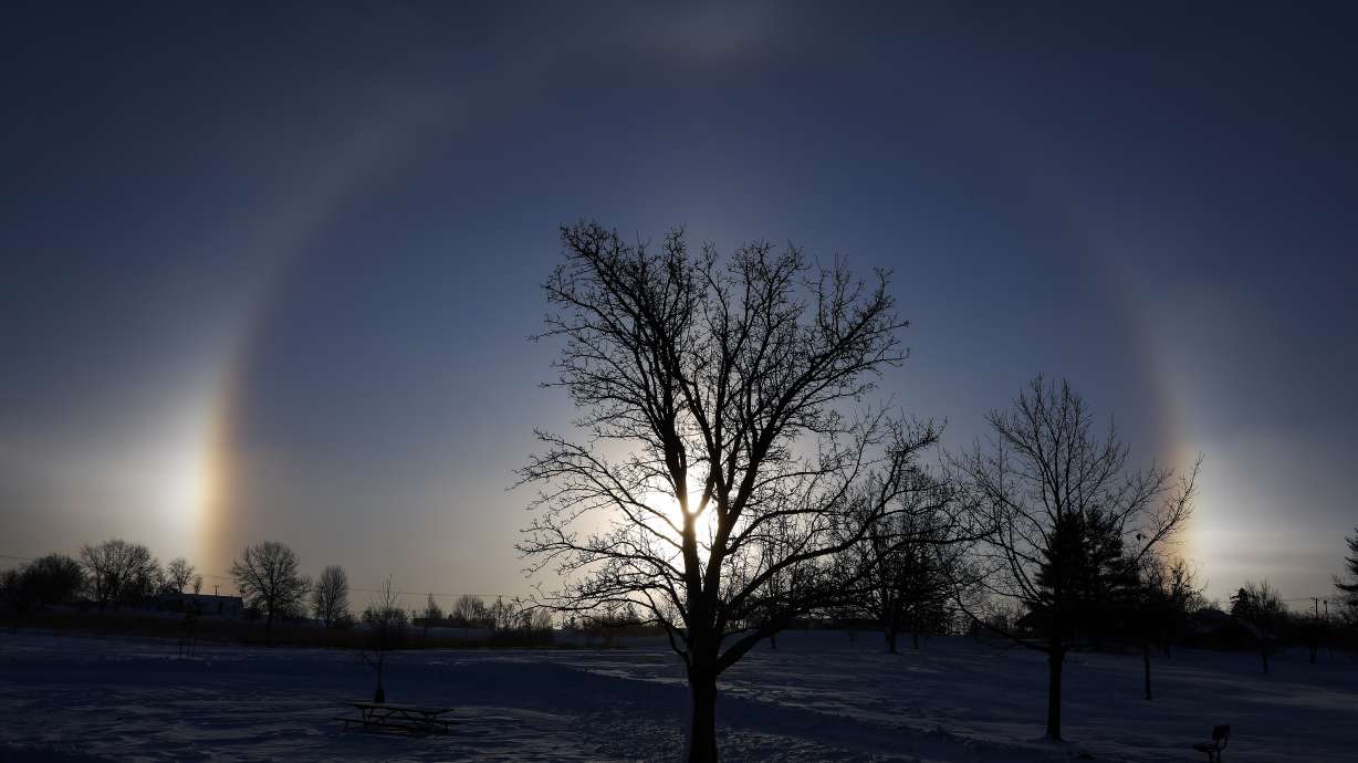 Sun dogs are seen on each side of the sun at Noelridge Park in northeast Cedar Rapids, Iowa, on Sunday. The optical illusions are caused by the refraction of sunlight by ice crystals in the atmosphere.