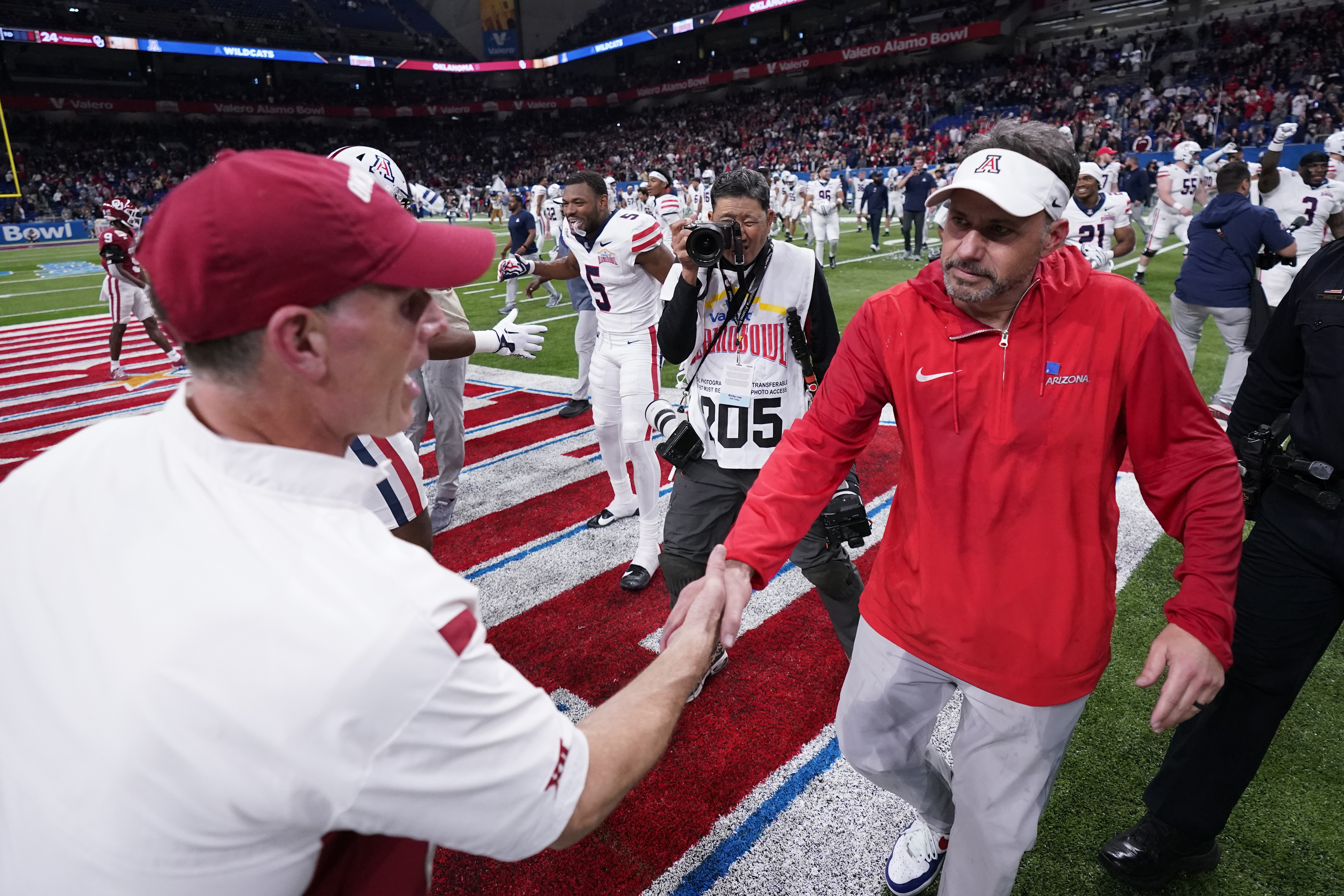 Oklahoma head coach Brent Venables, left, and Arizona head coach Jedd Fisch, right, shake hands following the Alamo Bowl NCAA college football game in San Antonio, Thursday, Dec. 28, 2023.