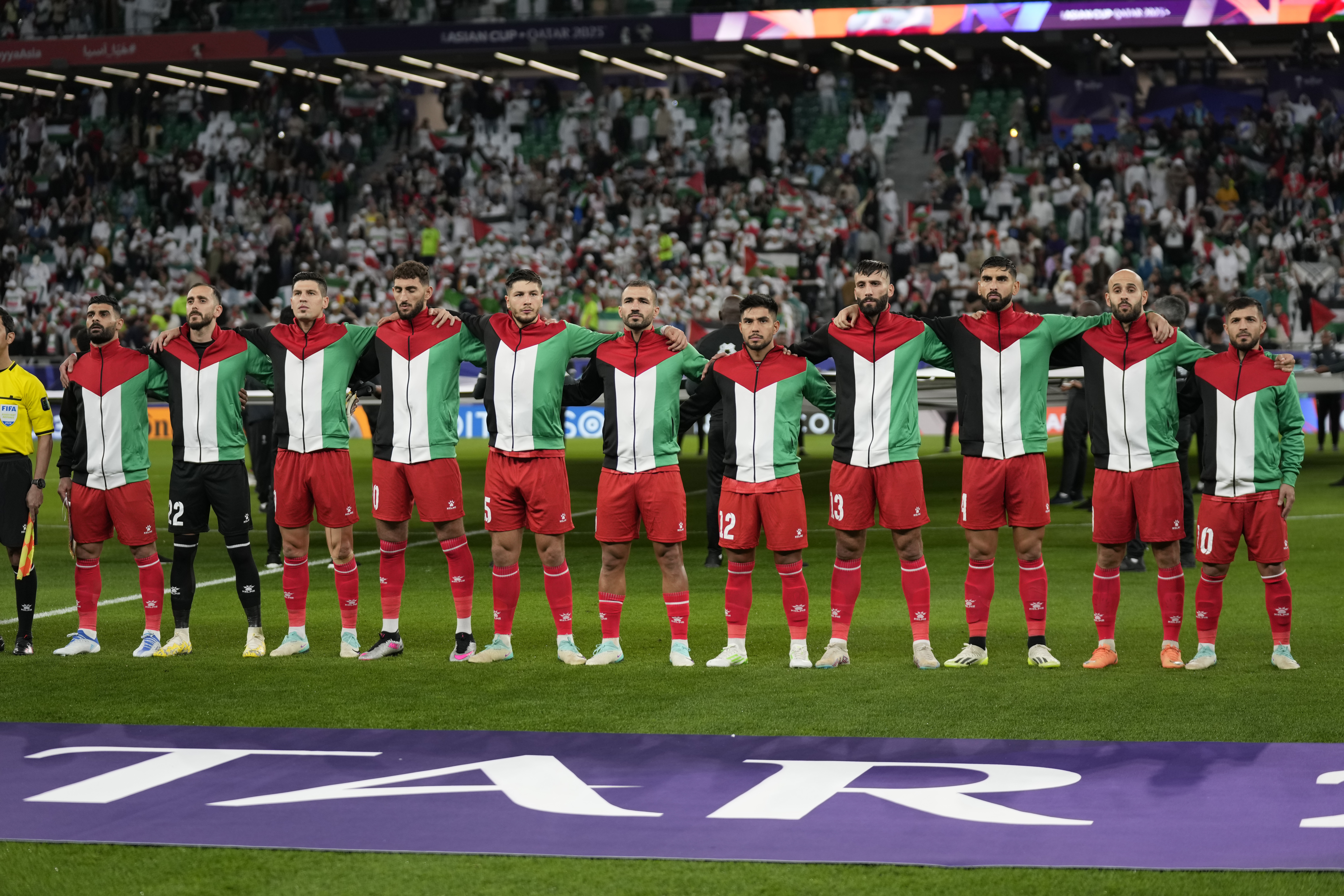 Palestinian team stand for the national anthem ahead of the Asian Cup Group C soccer match between Iran and Palestine at the Education City Stadium in Al Rayyan, Qatar, Sunday, Jan. 14, 2024. 