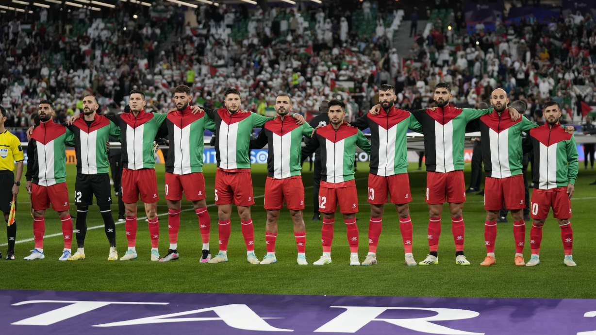 Palestinian team stand for the national anthem ahead of the Asian Cup Group C soccer match between Iran and Palestine at the Education City Stadium in Al Rayyan, Qatar, Sunday, Jan. 14, 2024.