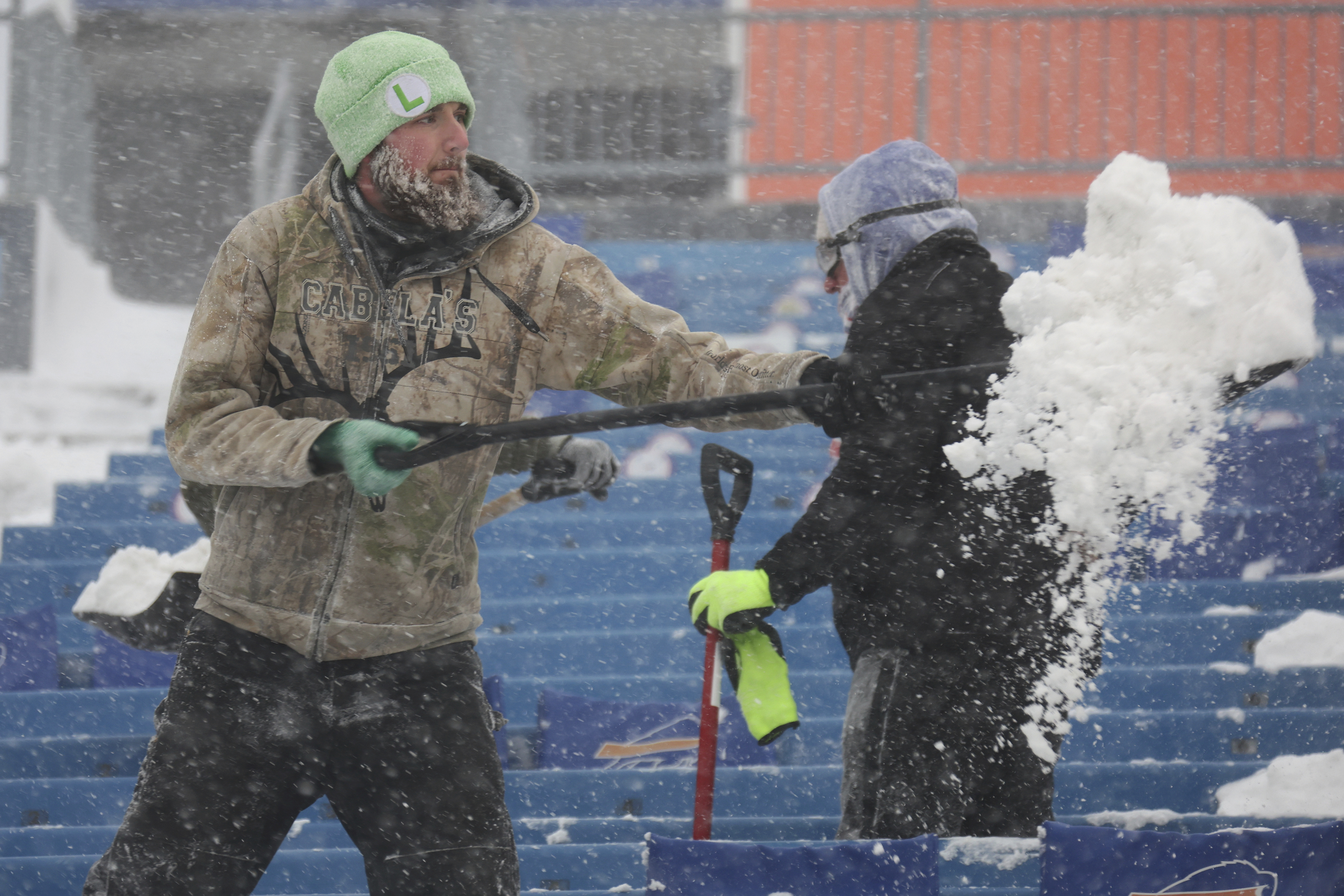 Workers remove snow from Highmark Stadium in Orchard Park, N.Y., Sunday Jan. 14, 2024. A potentially dangerous snowstorm that hit the Buffalo region on Saturday led the NFL to push back the Bills wild-card playoff game against the Pittsburgh Steelers from Sunday to Monday. New York Gov. Kathy Hochul and the NFL cited public safety concerns for the postponement, with up to 2 feet of snow projected to fall on the region over a 24- plus hour period. 