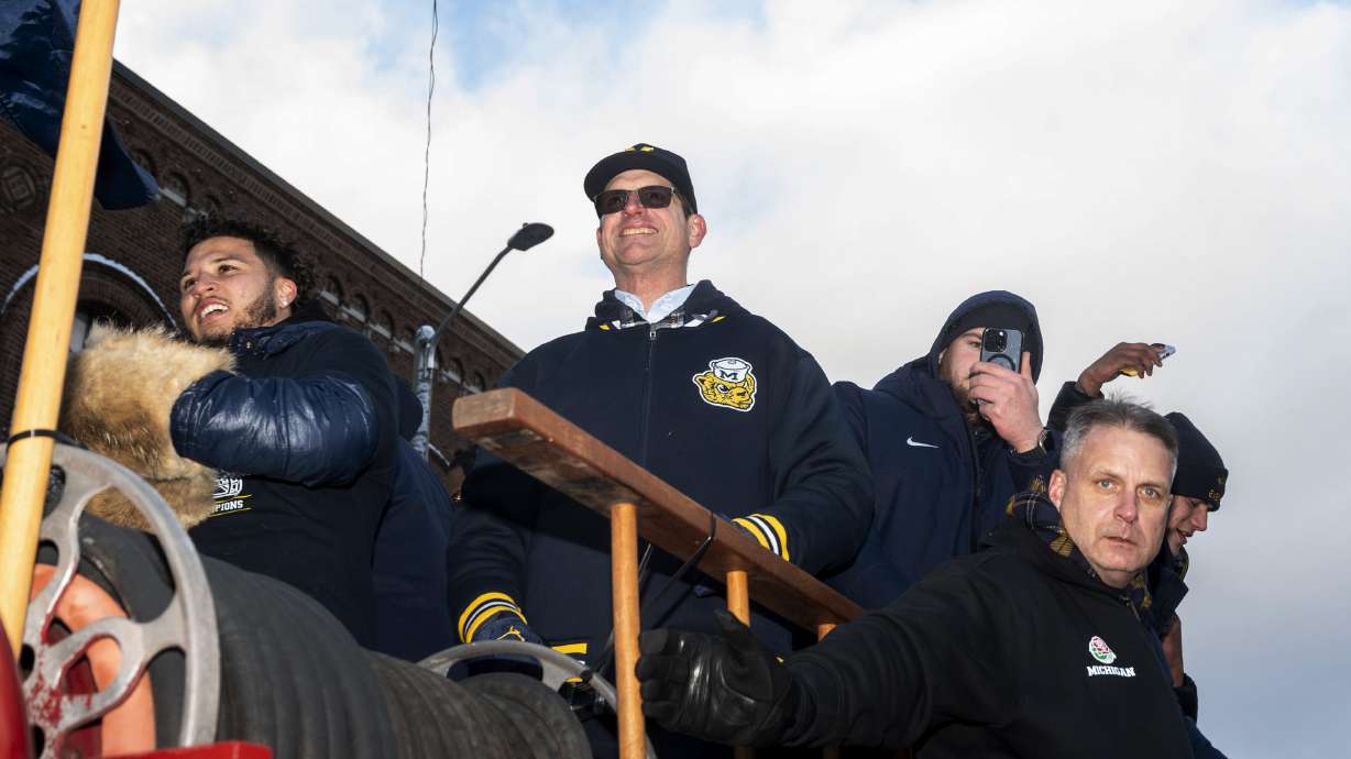 Michigan running back Blake Corum, coach Jim Harbaugh and offensive lineman Zak Zinter take part in a parade celebrating Michigan's college football title, in Ann Arbor, Mich., Saturday, Jan. 13, 2024.