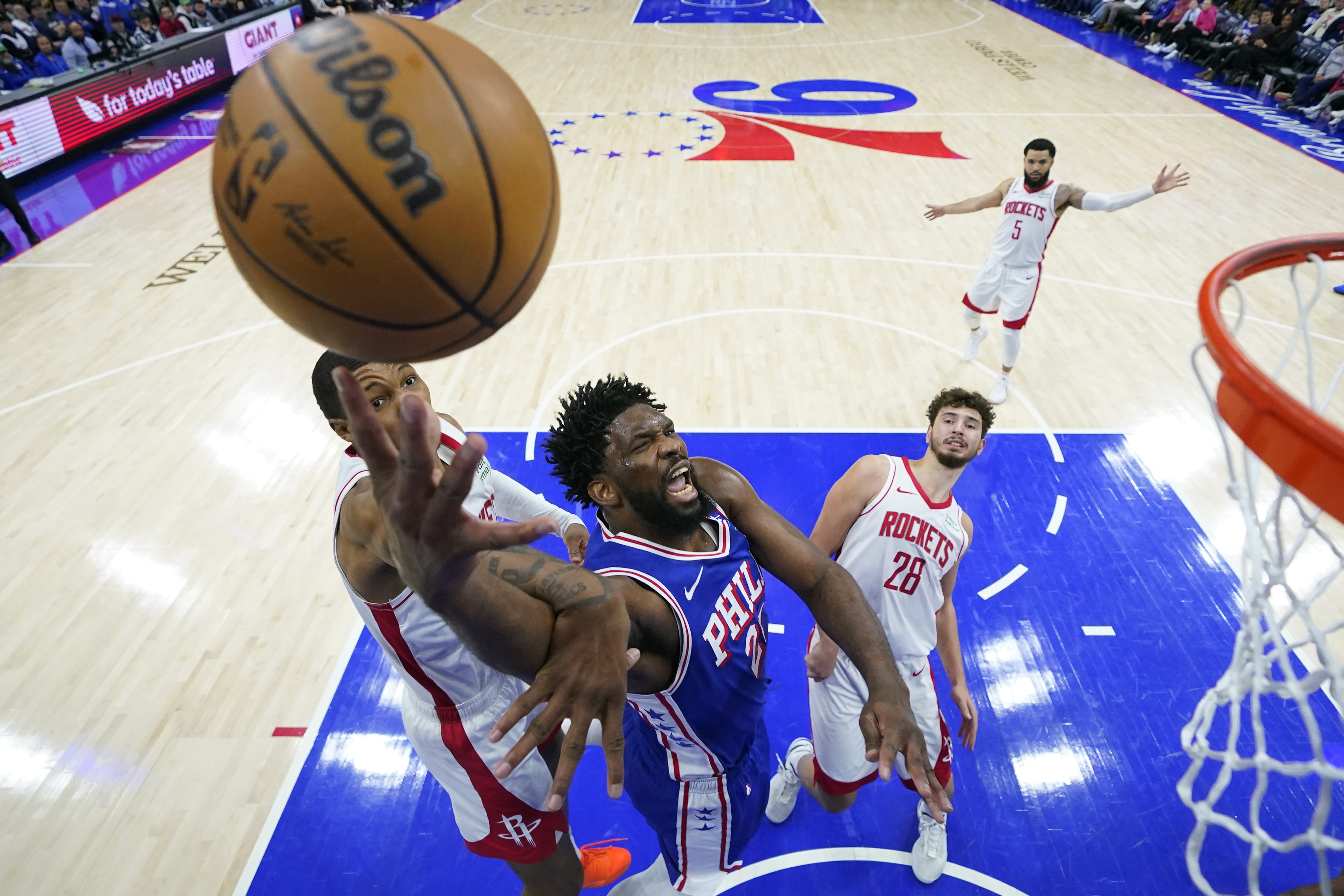 Philadelphia 76ers' Joel Embiid, center, goes up for a shot between Houston Rockets' Jabari Smith Jr., left, and Alperen Sengun during the second half of an NBA basketball game, Monday, Jan. 15, 2024, in Philadelphia. 