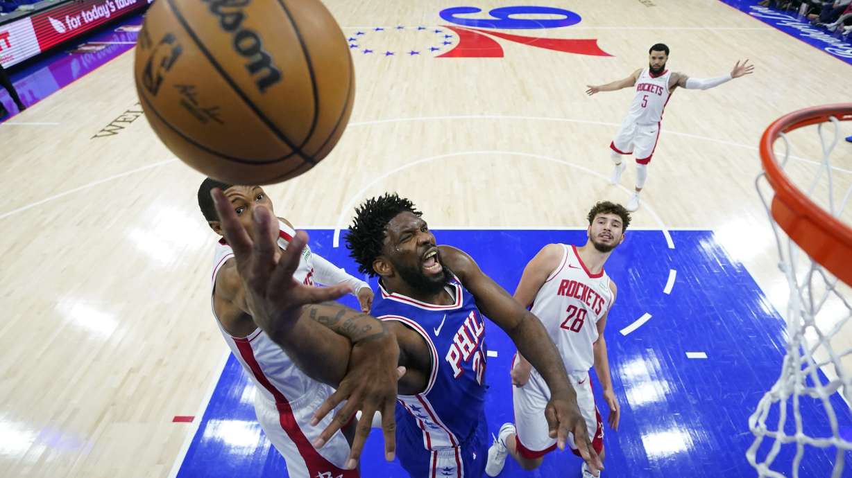 Philadelphia 76ers' Joel Embiid, center, goes up for a shot between Houston Rockets' Jabari Smith Jr., left, and Alperen Sengun during the second half of an NBA basketball game, Monday, Jan. 15, 2024, in Philadelphia.