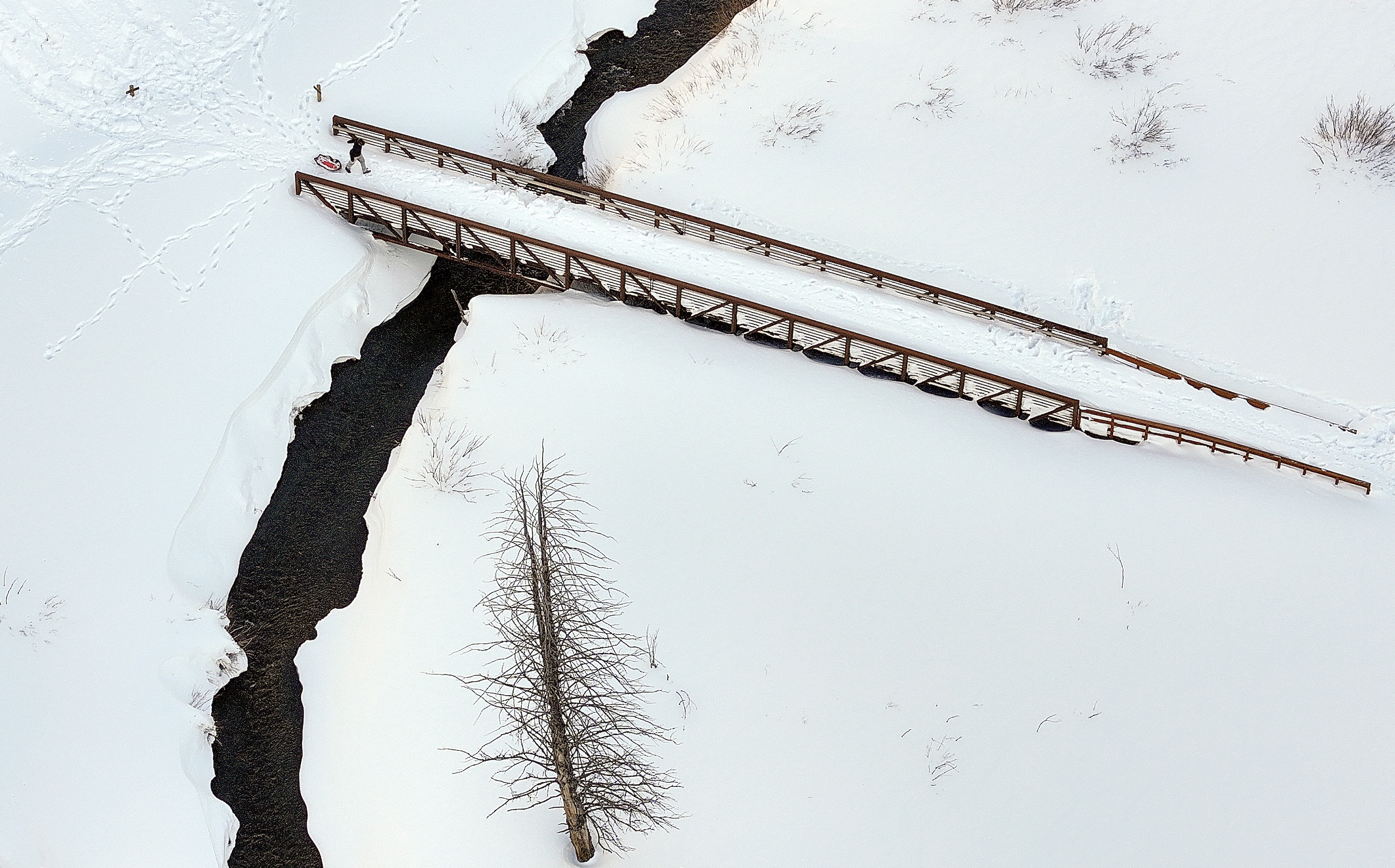 A sledder crosses a bridge in Big Cottonwood Canyon on Monday.