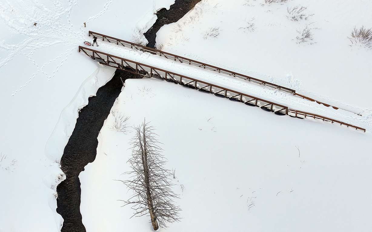 A sledder crosses a bridge in Big Cottonwood Canyon on Monday.