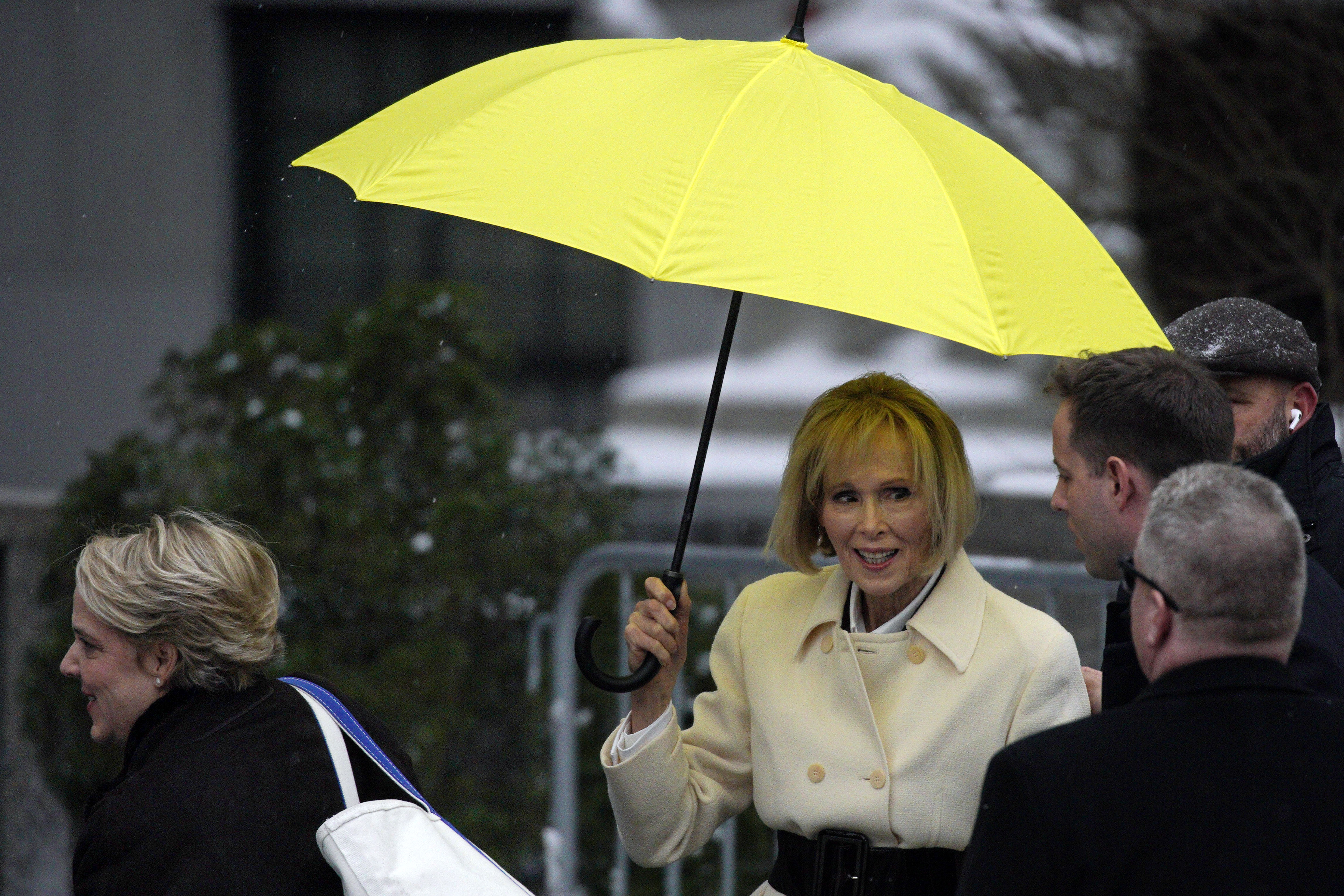 E. Jean Carroll, right, holds her umbrella as she arrives, with her attorney Roberta Kaplan, left, at federal court, in New York, Tuesday. Donald Trump was threatened with expulsion from the Manhattan civil trial Wednesday.