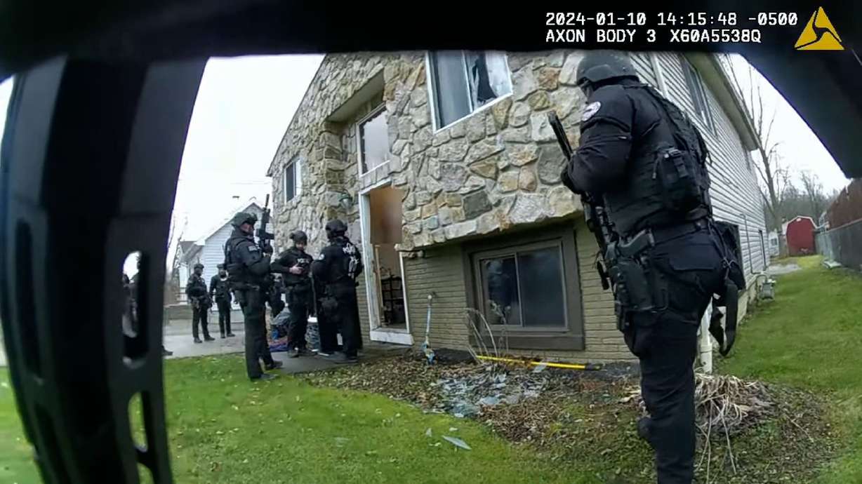A body-worn camera footage still shows Elyria Police Department officers gathered outside a home during a raid on Jan. 10.