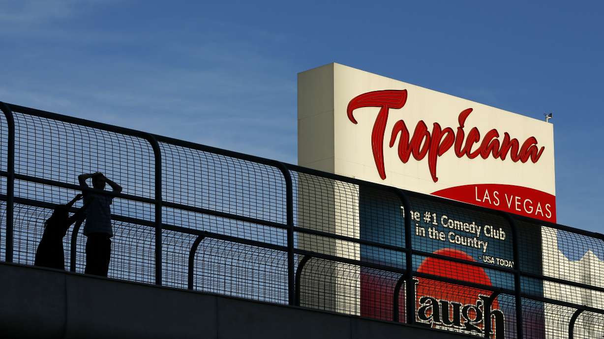 People stand on a pedestrian bridge by the Tropicana Hotel and Casino in Las Vegas, Aug. 4, 2015. Stopping or standing is prohibited on Las Vegas Strip pedestrian bridges after a new ordinance took effect Tuesday.