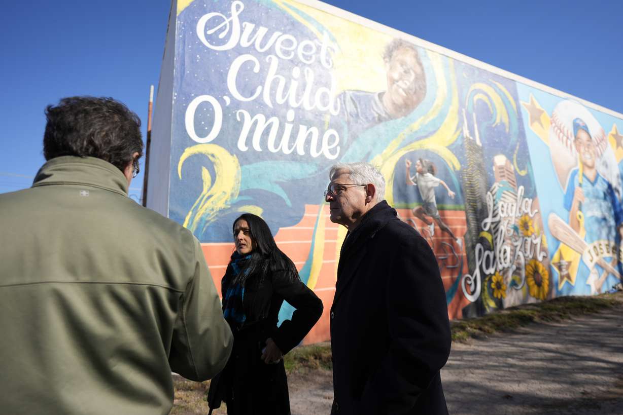 Artist Abel Ortiz, left, gives Attorney General Merrick Garland, right, and Associate Attorney General Vanita Gupta, center, a tour of murals of shooting victims, Wednesday in Uvalde, Texas. The Justice Department on Thursday released findings of an investigation into the 2022 school shooting.