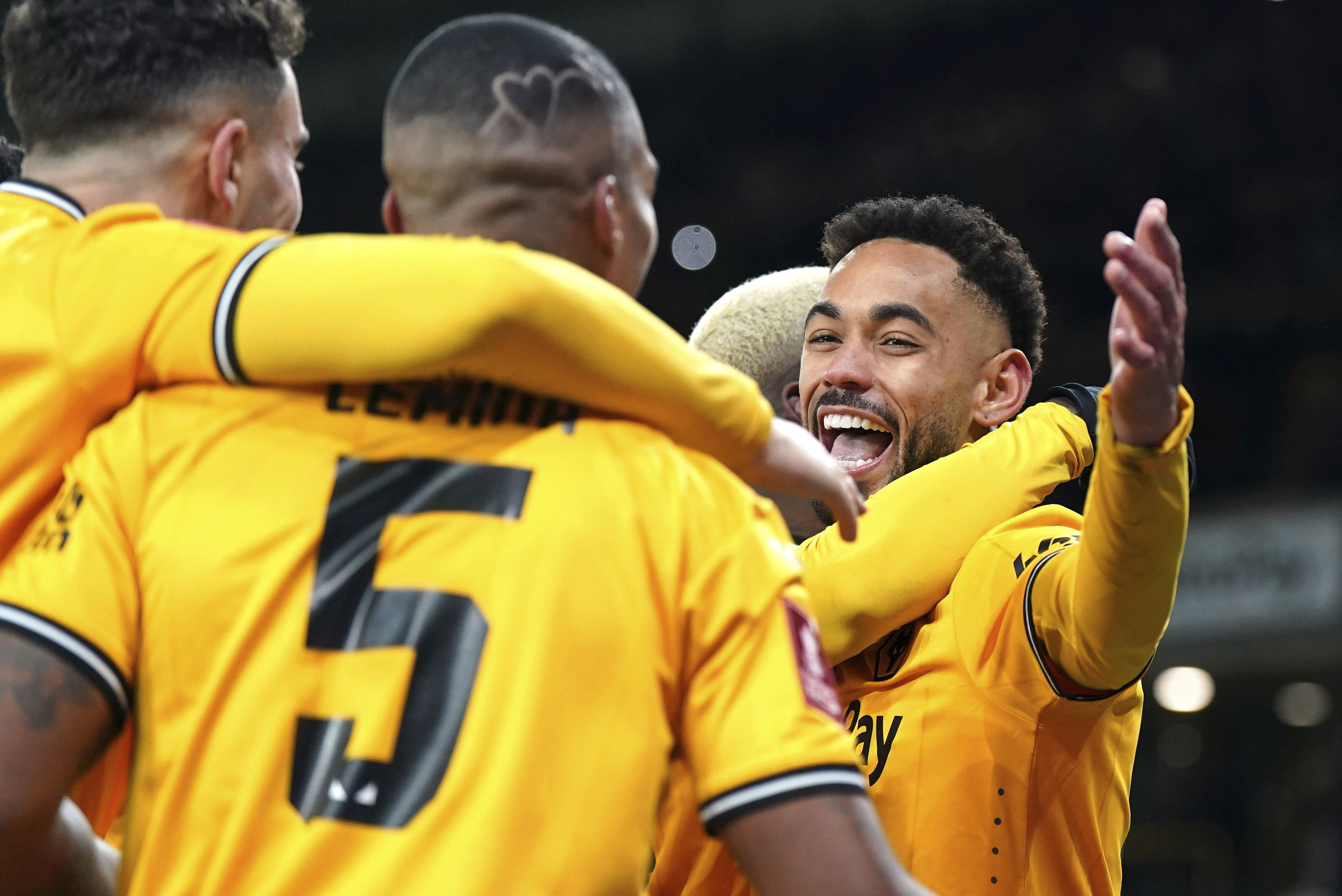 Wolverhampton Wanderers' Matheus Cunha, right, celebrates scoring their side's third goal of the game from the penalty spot with teammates in extra time during the English FA Cup third round replay soccer match between Wolverhampton Wanderers and Brentford at the Molineux Stadium, Wolverhampton, England, Tuesday, Jan. 16, 2024. 