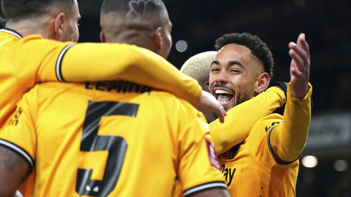 Wolverhampton Wanderers' Matheus Cunha, right, celebrates scoring their side's third goal of the game from the penalty spot with teammates in extra time during the English FA Cup third round replay soccer match between Wolverhampton Wanderers and Brentford at the Molineux Stadium, Wolverhampton, England, Tuesday, Jan. 16, 2024.