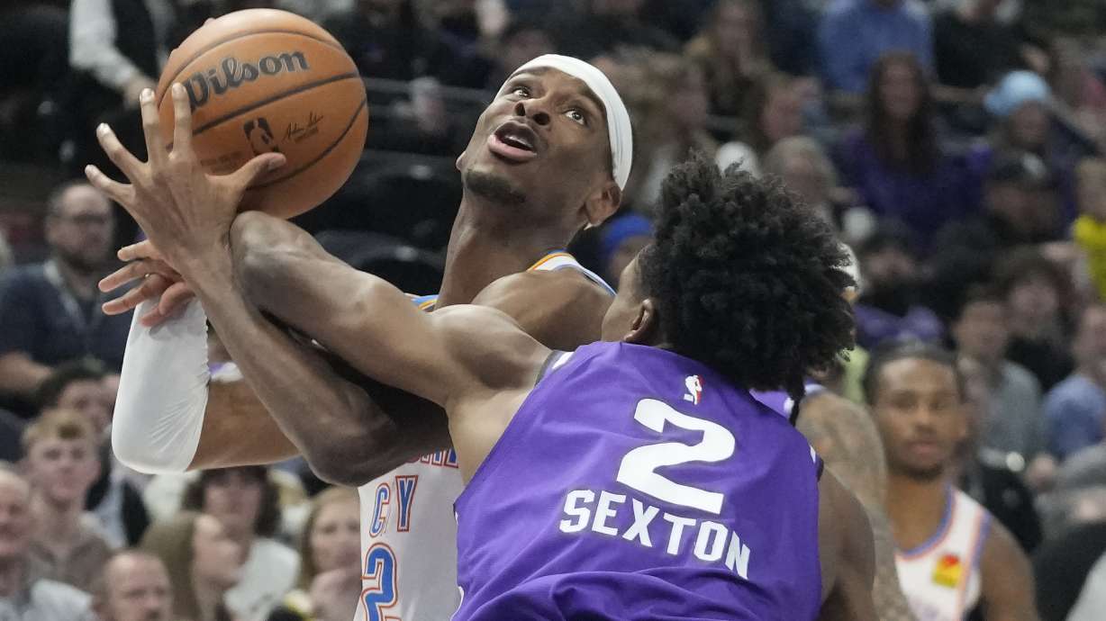 Utah Jazz guard Collin Sexton (2) fouls Oklahoma City Thunder guard Shai Gilgeous-Alexander (2) during the first half of an NBA basketball game Thursday, Jan. 18, 2024, in Salt Lake City.