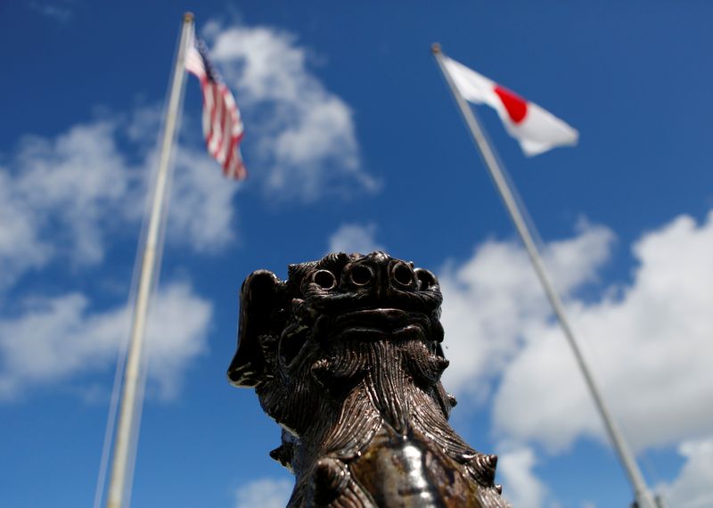 The U.S. (L) and Japanese national flags are hoisted next to a traditional Okinawan Shisa statue at the U.S. Marine's Camp Foster in Ginowan, on the southern island of Okinawa, Japan, June 18, 2016. U.S. Ambassador to Japan Rahm Emanuel expressed regret for the handling of two cases of sexual assaults allegedly committed by American military personnel on Okinawa.