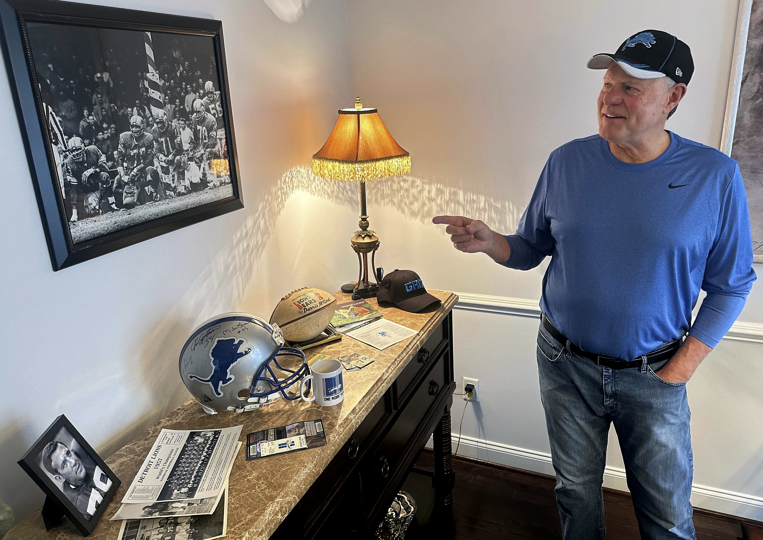 Mike McCord points to a photo of his late father, Darris, who was a Pro Bowl defensive lineman for the 1957 NFL football champion Detroit Lions, at his home in Northville, Mich., Thursday, Jan. 18, 2024. The 68-year-old McCord has been attending Lions home games for six-plus decades and hopes this is the year they play in the Super Bowl for the first time.