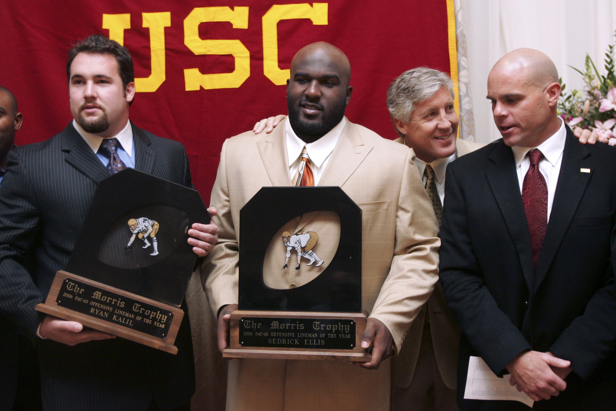 FILE - Southern California coach Pete Carroll chats with defensive coordinator Nick Holt, right, during a photo session with Morris Trophy winners, center Ryan Kalil, left, and nose tackle Sedrick Ellis, both of USC, at the Washington Athletic Club in Seattle, Jan. 18, 2007. The Morris Trophy was never a name-brand award handed out following the college football season, in part because it honored offensive and defensive linemen, players who sometimes don't get the recognition they deserve. But it was special on the West Coast and special to the Pac-10 or Pac-12. Every year since 1980 it's been awarded, and perhaps most notably was voted on by the players themselves. Coaches and media had no influence in the final decision. 