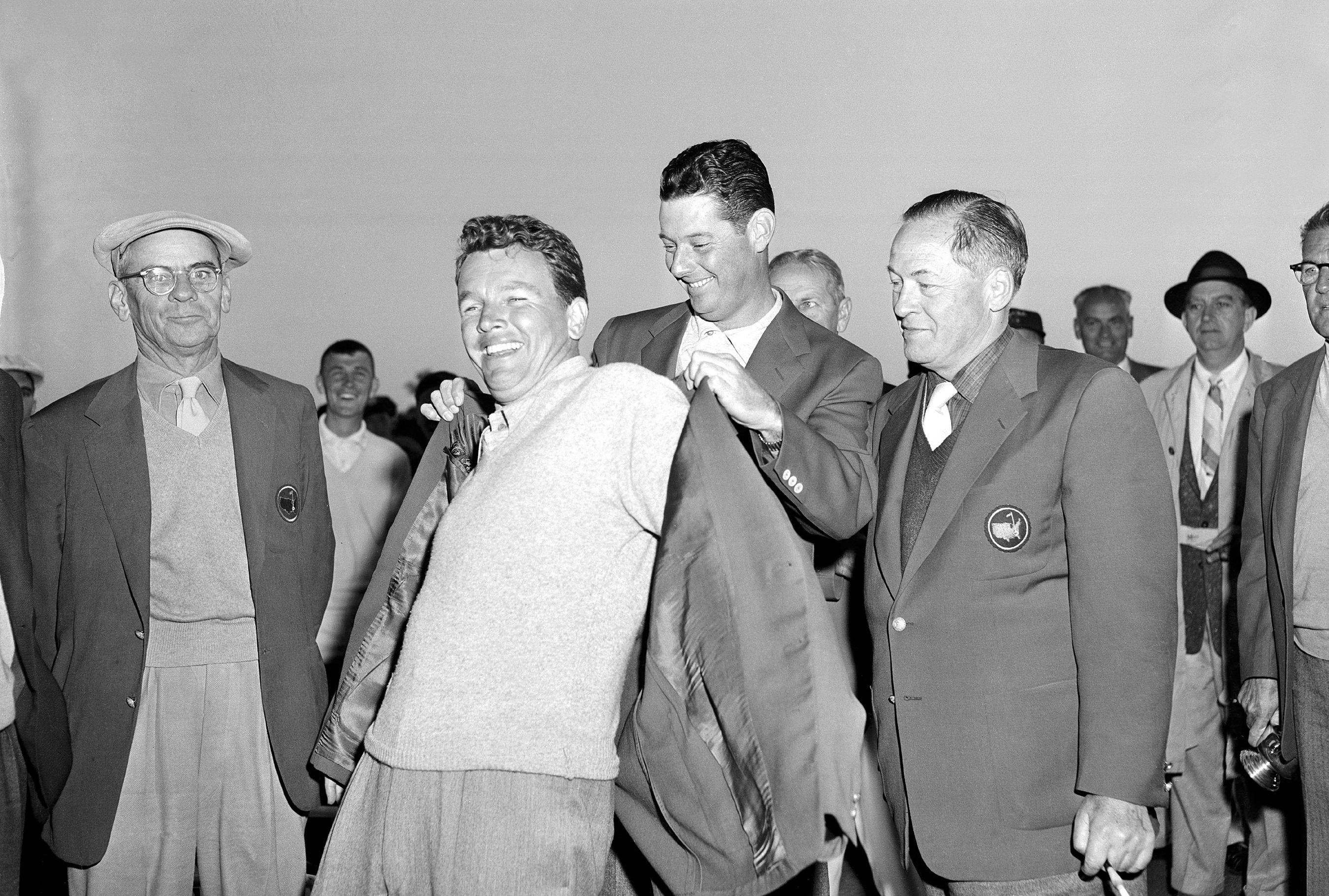 FILE - Jack Burke Jr. is helped by Cary Middlecoff as he puts on the traditional coat after winning the 20th Masters Golf Tournament at the Augusta National Golf Course in Augusta, Ga., April 8, 1956. Jack Burke Jr., the oldest living Masters champion who staged the greatest comeback ever at Augusta National for one of his two majors, died Friday morning, Jan. 19, 2024, in Houston. He was 100.