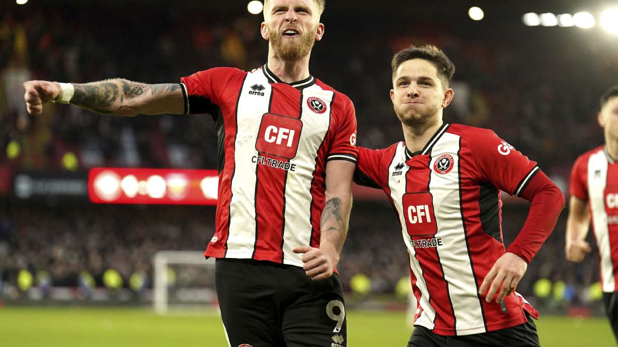 Sheffield United's Oli McBurnie, lwft, celebrates scoring his side's second goal of the game from a penalty kick during the English Premier League soccer match between Sheffield United and West Ham United at Bramall Lane, in Sheffield, England, Sunday, Jan. 21, 2024.