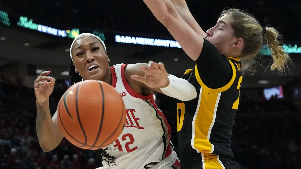 Iowa guard Kate Martin, right, knocks the ball away from Ohio State forward Cotie McMahon, left, in the first half of an NCAA college basketball game Sunday, Jan. 21, 2024, in Columbus, Ohio.