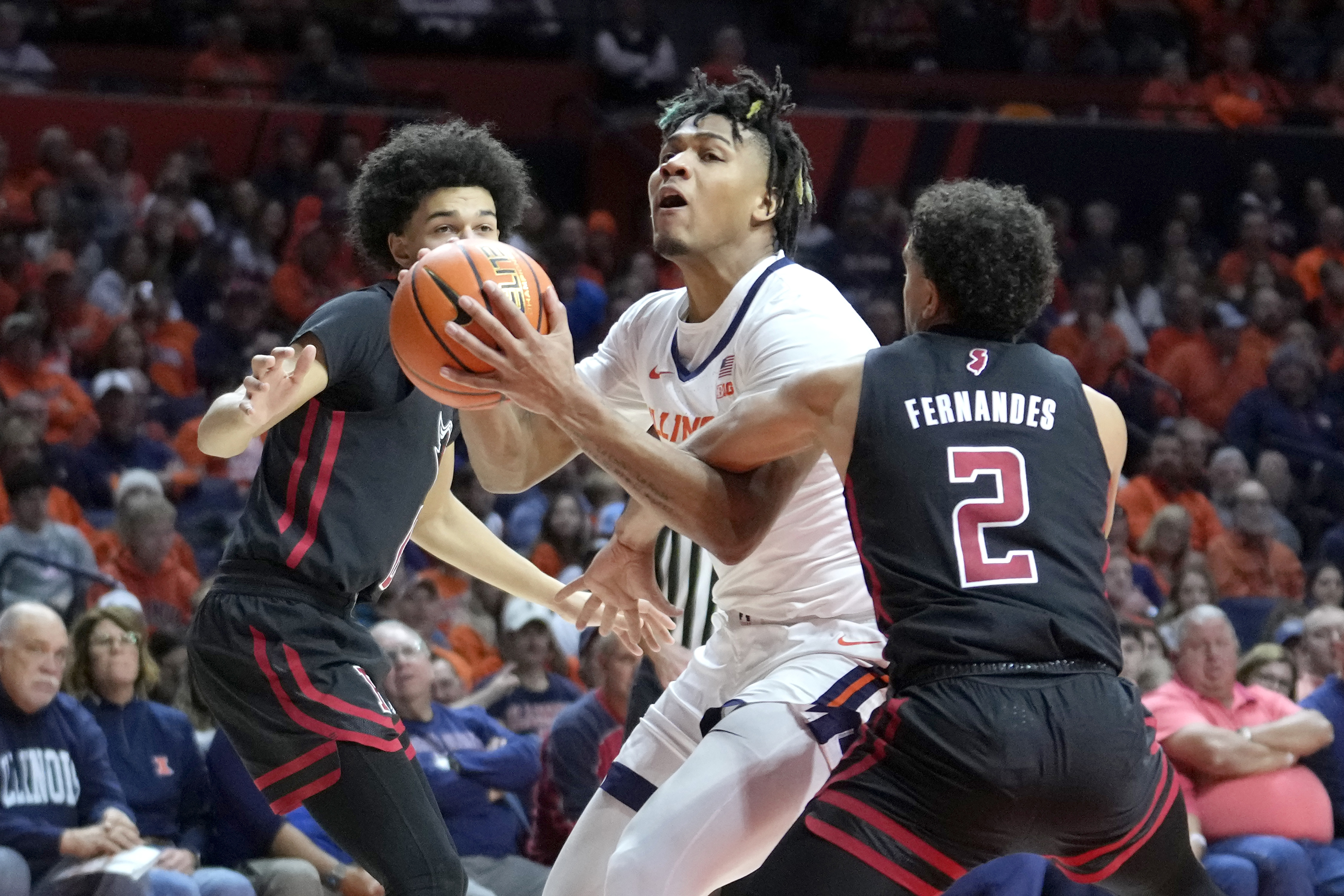 Illinois' Terrence Shannon Jr., center, drives to the basket between Rutgers' Derek Simpson, left, and Noah Fernandes during the first half of an NCAA college basketball game Sunday, Jan. 21, 2024, in Champaign, Ill. 