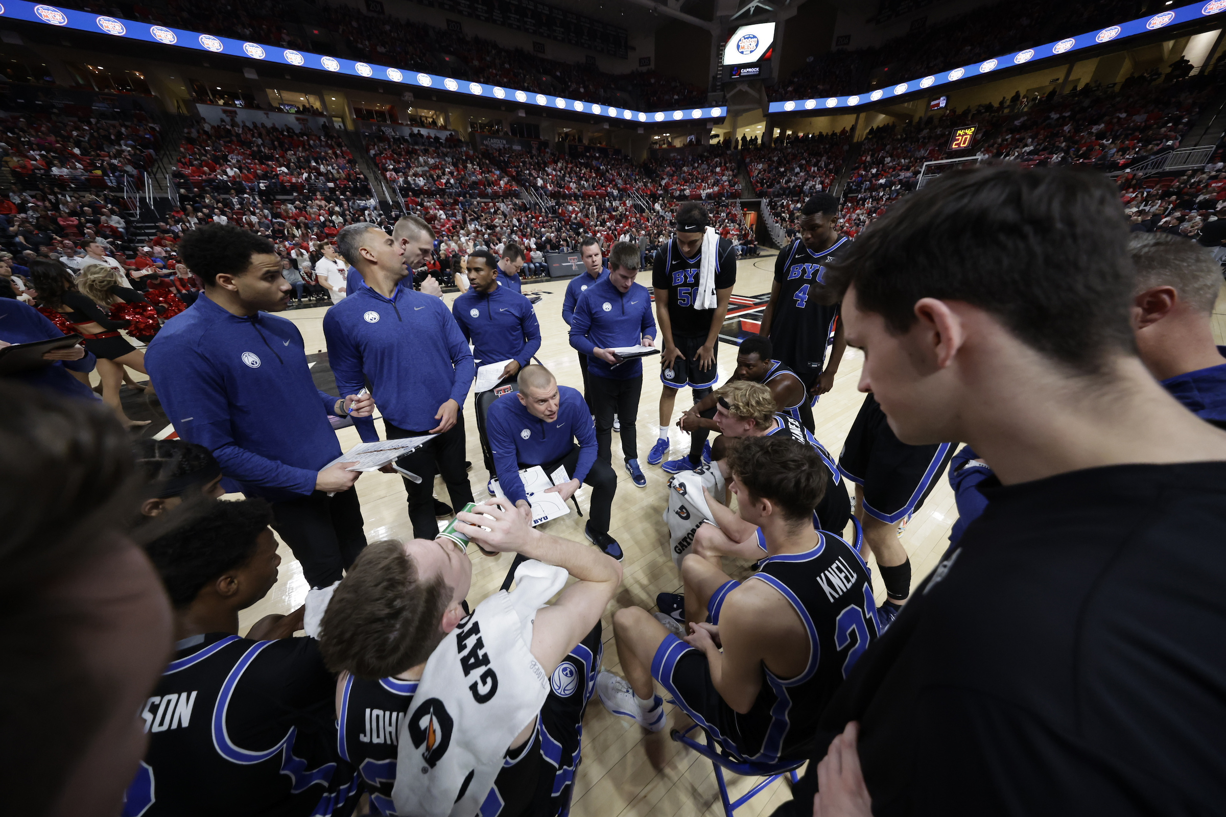 BYU coach Mark Pope, center, during a timeout in a Big 12 men's basketball game against No. 25 Texas Tech, Saturday, Jan. 20, 2024, at United Supermarkets Arena in Lubbock, Texas.