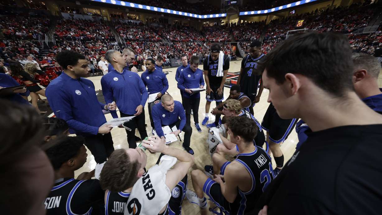 BYU coach Mark Pope, center, during a timeout in a Big 12 men's basketball game against No. 25 Texas Tech, Saturday, Jan. 20, 2024, at United Supermarkets Arena in Lubbock, Texas.