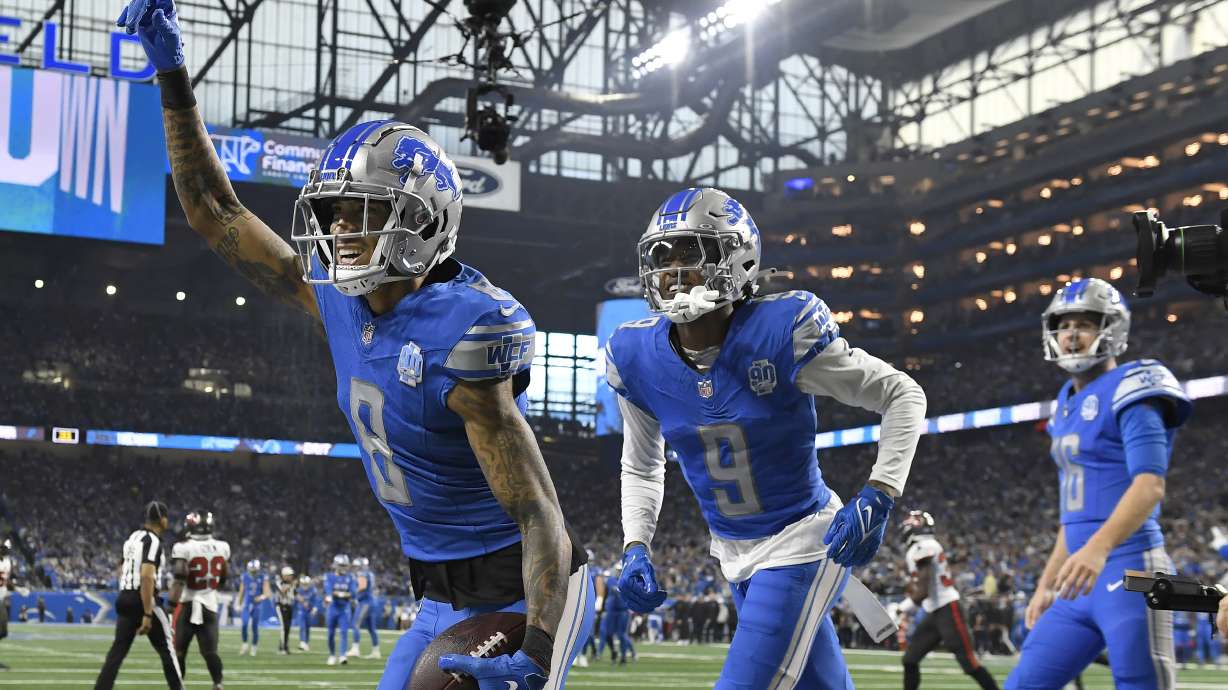 Detroit Lions wide receiver Josh Reynolds (8) celebrates with teammates Jameson Williams (9) and Jared Goff (16) after scoring a touchdown against the Tampa Bay Buccaneers during the first half of an NFL football NFC divisional playoff game, Sunday, Jan. 21, 2024, in Detroit.