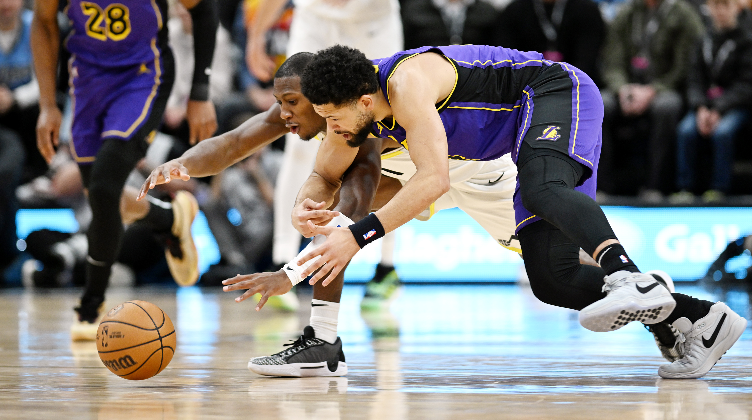 Utah Jazz guard Kris Dunn (11) and Los Angeles Lakers guard Skylar Mays (4) chase after a loose ball as Utah and Los Angeles play at the Delta Center in Salt Lake City on Saturday, Jan. 13, 2024. Utah won 132-125.