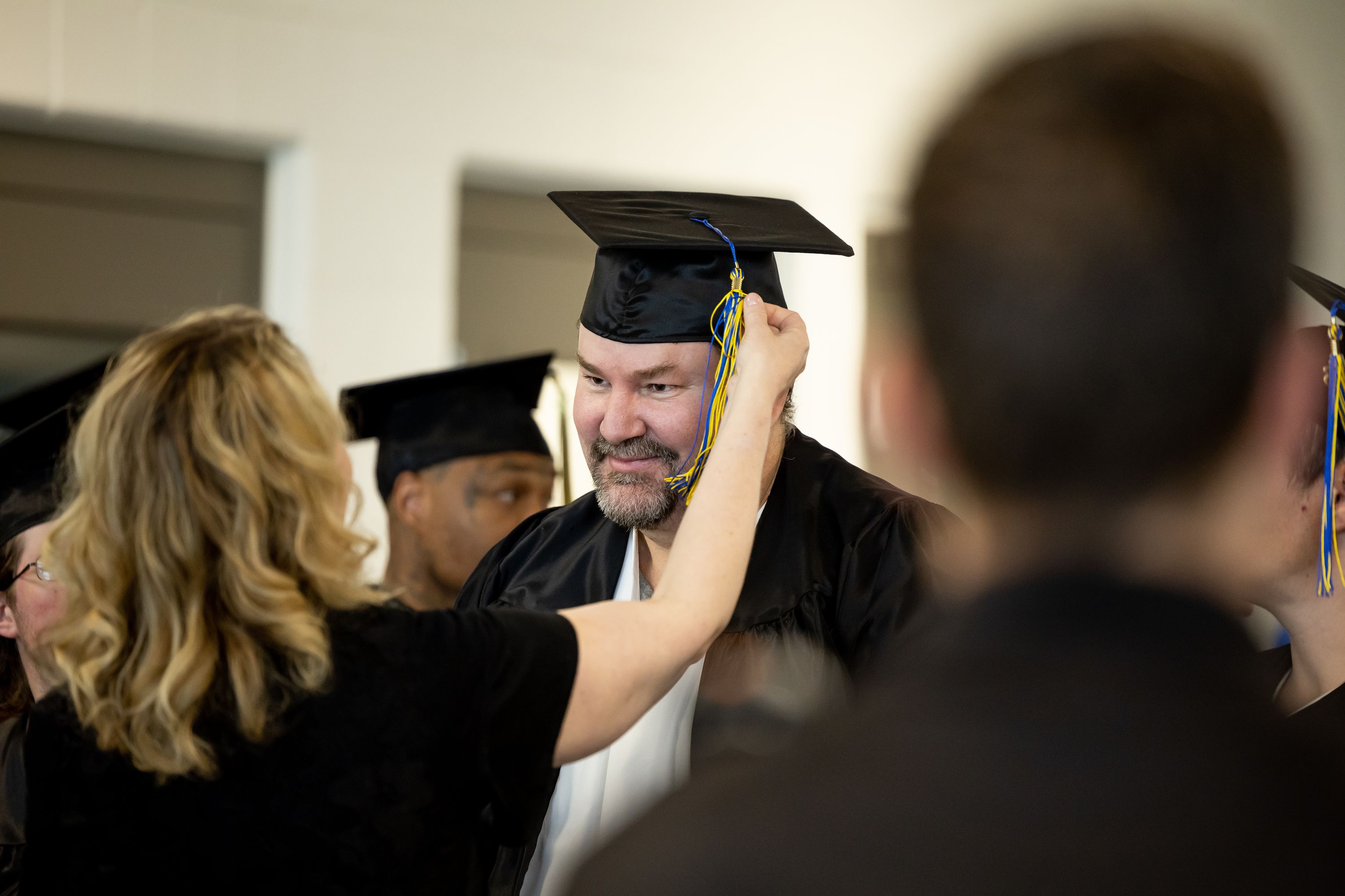 Kevin Peterson gets some help adjusting his tassel at the end of a commencement ceremony for incarcerated individuals earning their high school diploma at the Utah State Correctional Facility in Salt Lake City on June 5, 2023.
