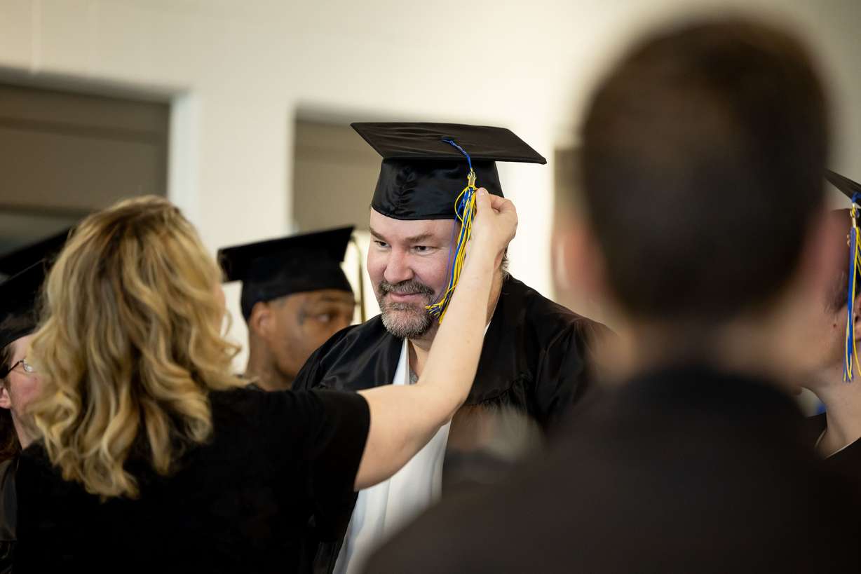 Kevin Peterson gets some help adjusting his tassel at the end of a commencement ceremony for incarcerated individuals earning their high school diploma at the Utah State Correctional Facility in Salt Lake City on June 5, 2023.