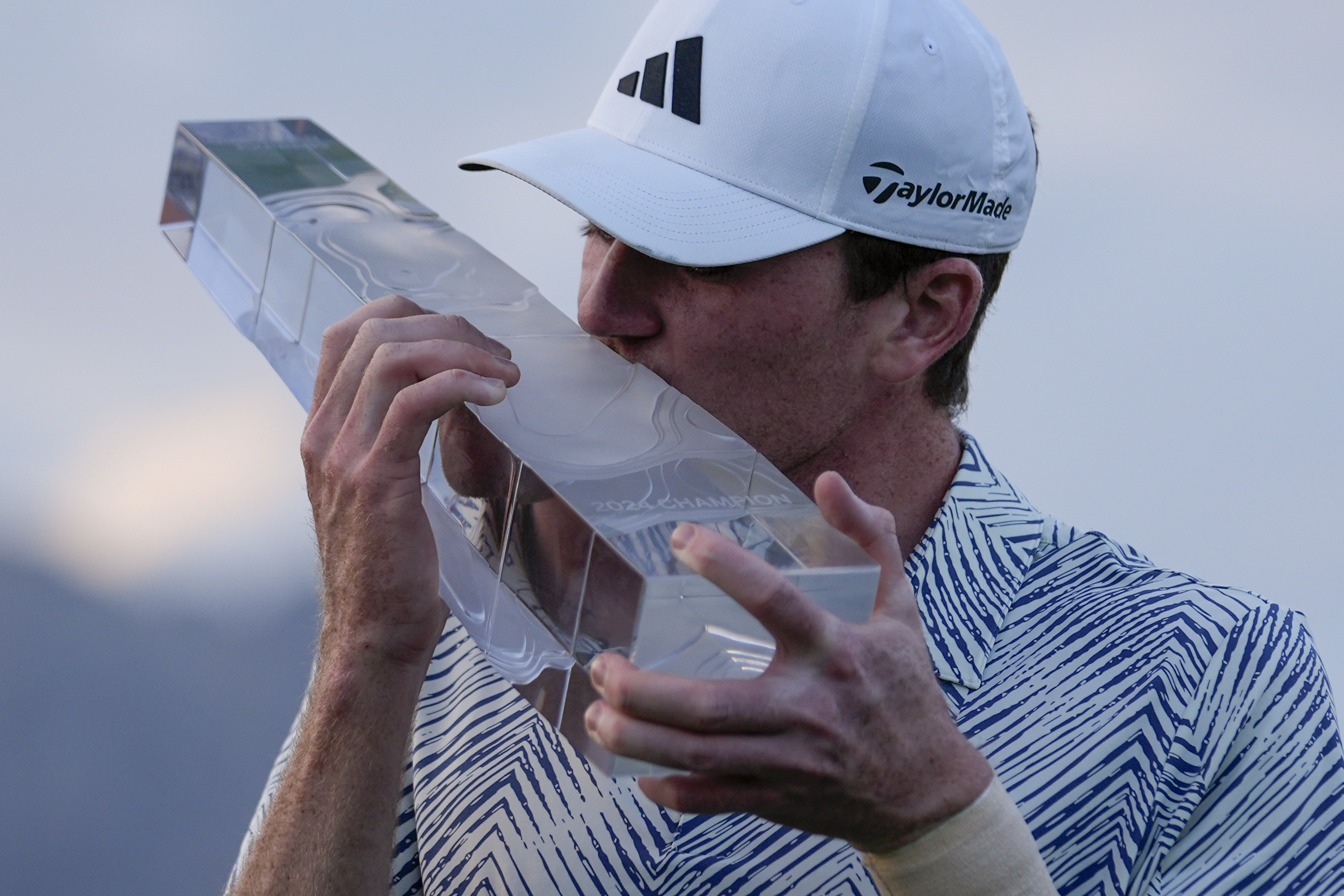 Nick Dunlap kisses the trophy after winning the American Express golf tournament, Sunday, Jan. 21, 2024, in La Quinta, Calif. 