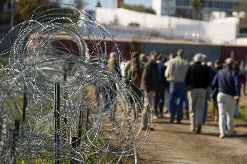 Concertina wire lines the path as members of Congress tour an area near the Texas-Mexico border, Jan. 3, in Eagle Pass, Texas. 