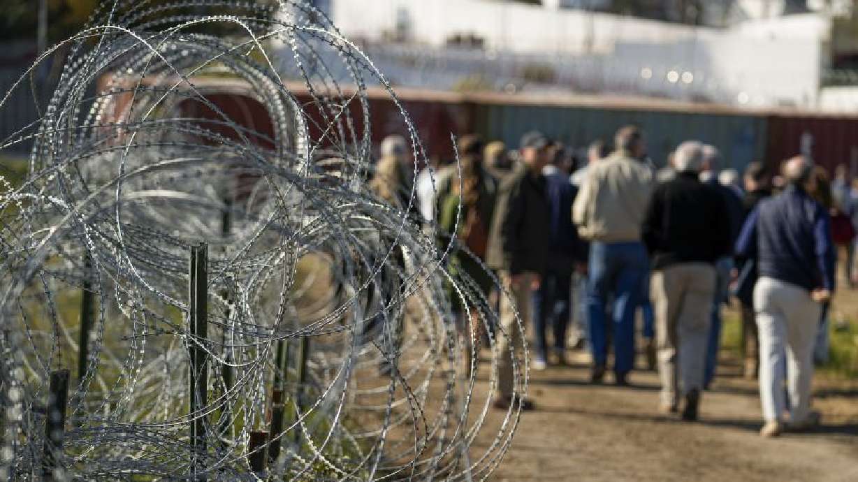 Concertina wire lines the path as members of Congress tour an area near the Texas-Mexico border, Jan. 3, in Eagle Pass, Texas.