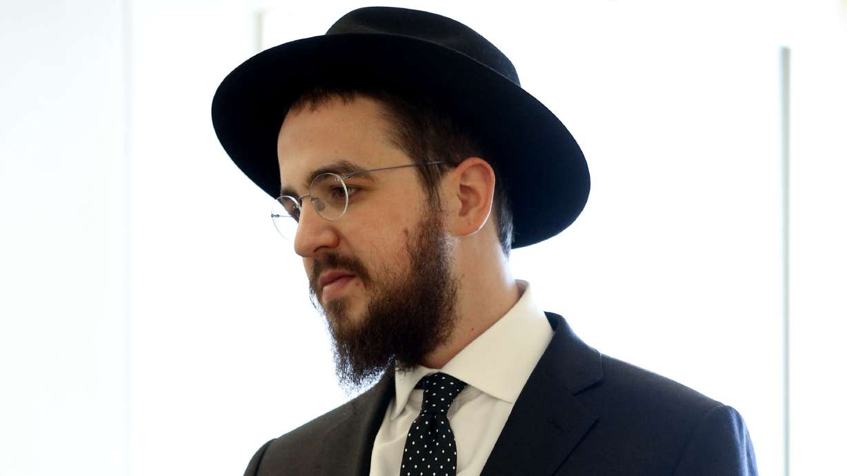 Rabbi Avrohom “Avremi” Zippel holds his statement and a photo of himself when he was 8 after his childhood nanny was sentenced in Salt Lake City on March 12, 2020. On Friday, the Utah Court of Appeals upheld her conviction and sentence.