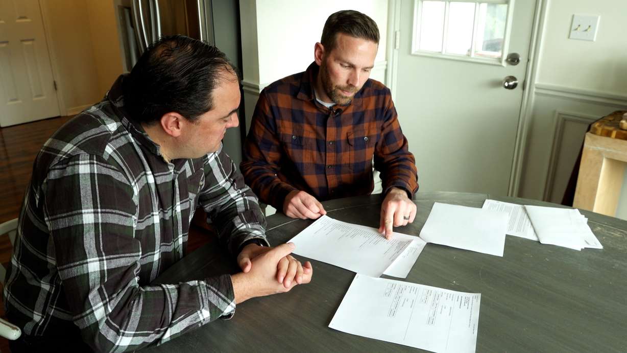 Andy Petersen, right, shows KSL-TV’s Matt Gephardt an insurance loss report detailing several claims he says he’s never made but are driving up his home and auto insurance prices.