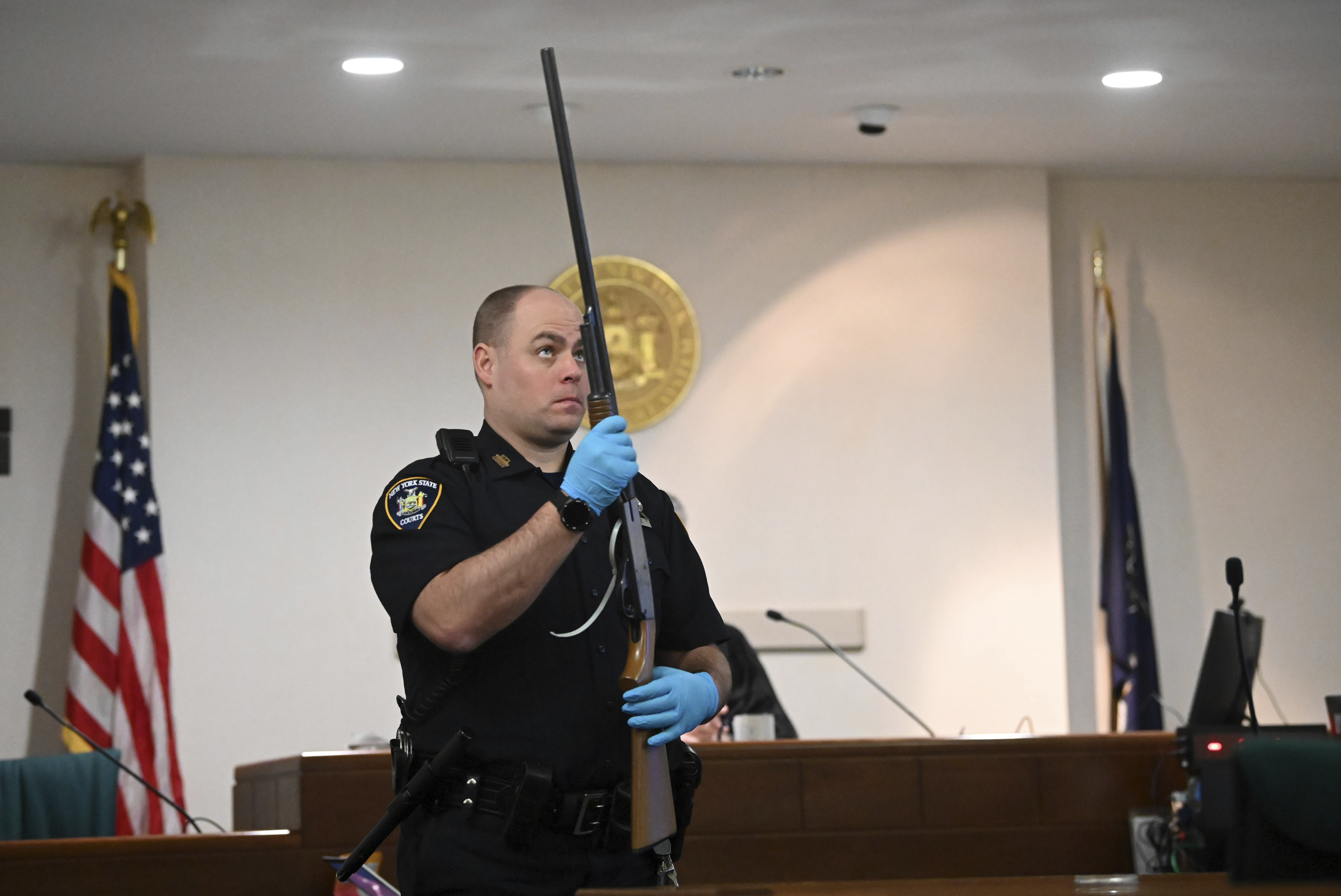 A New York Court police officer holds Kevin Monahan's shotgun during summations in Monahan's murder trial, Tuesday, at the Washington County Courthouse in Fort Edward, N.Y.