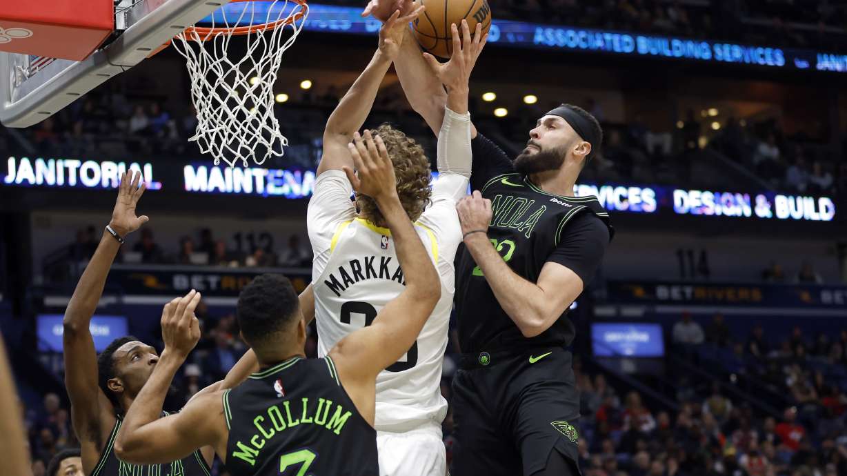 Utah Jazz forward Lauri Markkanen is fouled by New Orleans Pelicans forward Larry Nance Jr., right, during the first half of an NBA basketball game in New Orleans, Tuesday, Jan. 23, 2024.