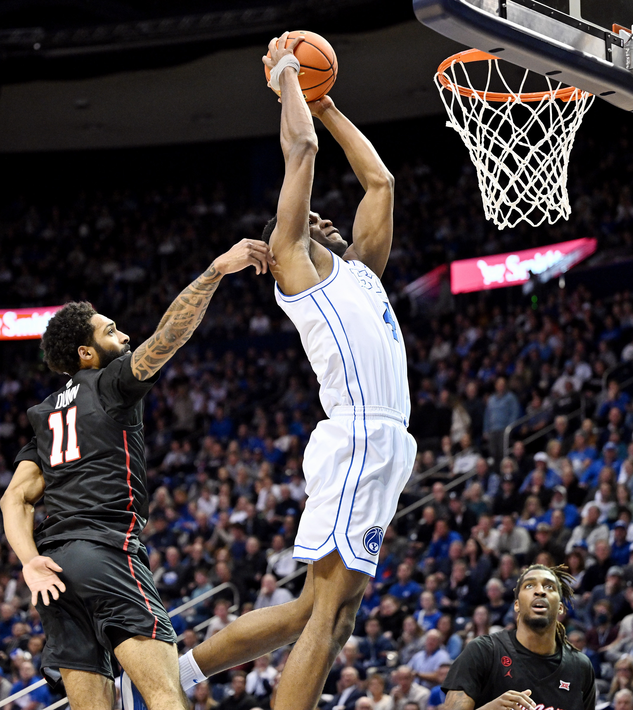 Brigham Young forward Atiki Ally Atiki (4) catches pass for a dunk and is fouled by Houston guard Damian Dunn (11) as BYU and Houston play at the Marriott Center in Provo on Tuesday, Jan. 23, 2024.