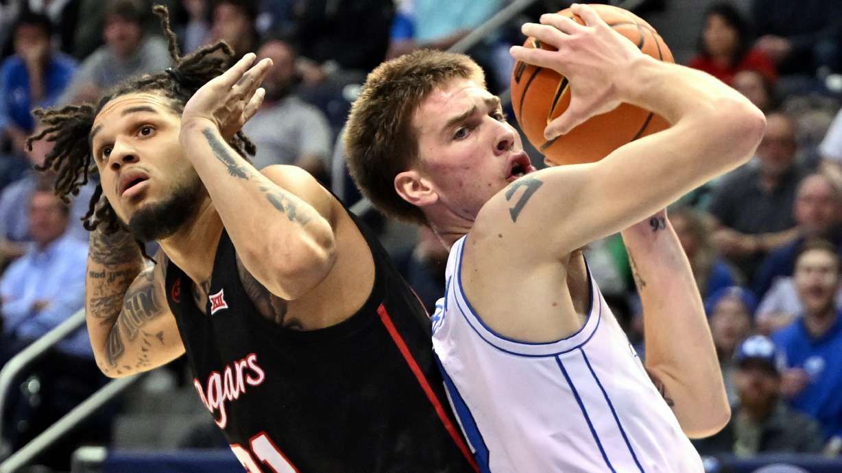 Houston Cougars guard Emanuel Sharp (21) is called for a foul on Brigham Young Cougars forward Noah Waterman (0) as BYU and Houston play at the Marriott Center in Provo on Tuesday, Jan. 23, 2024.