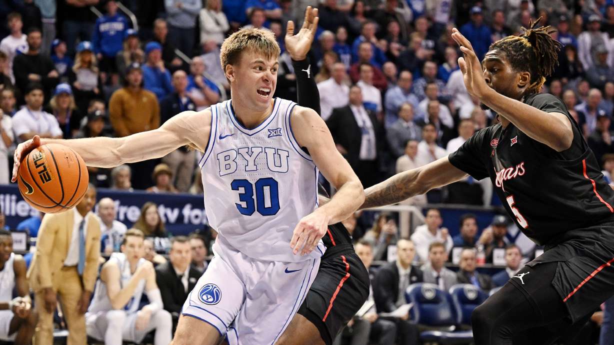 Brigham Young guard Dallin Hall (30) goes under the hoop with Houston forward Ja'Vier Francis (5) defending him as BYU and Houston play at the Marriott Center in Provo on Tuesday, Jan. 23, 2024. Houston won 75-68.