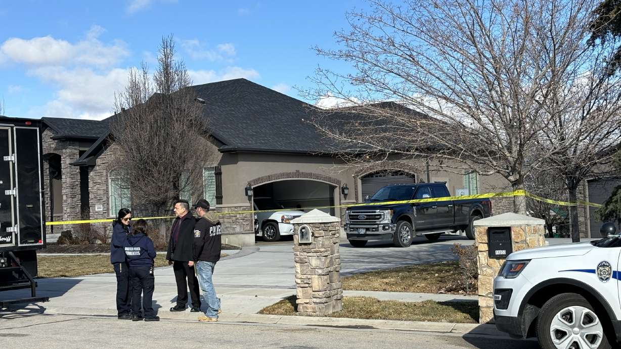 Police tape is displayed in front of a Bluffdale home where police shot and killed a man Wednesday after they say he pointed a gun at first responders.