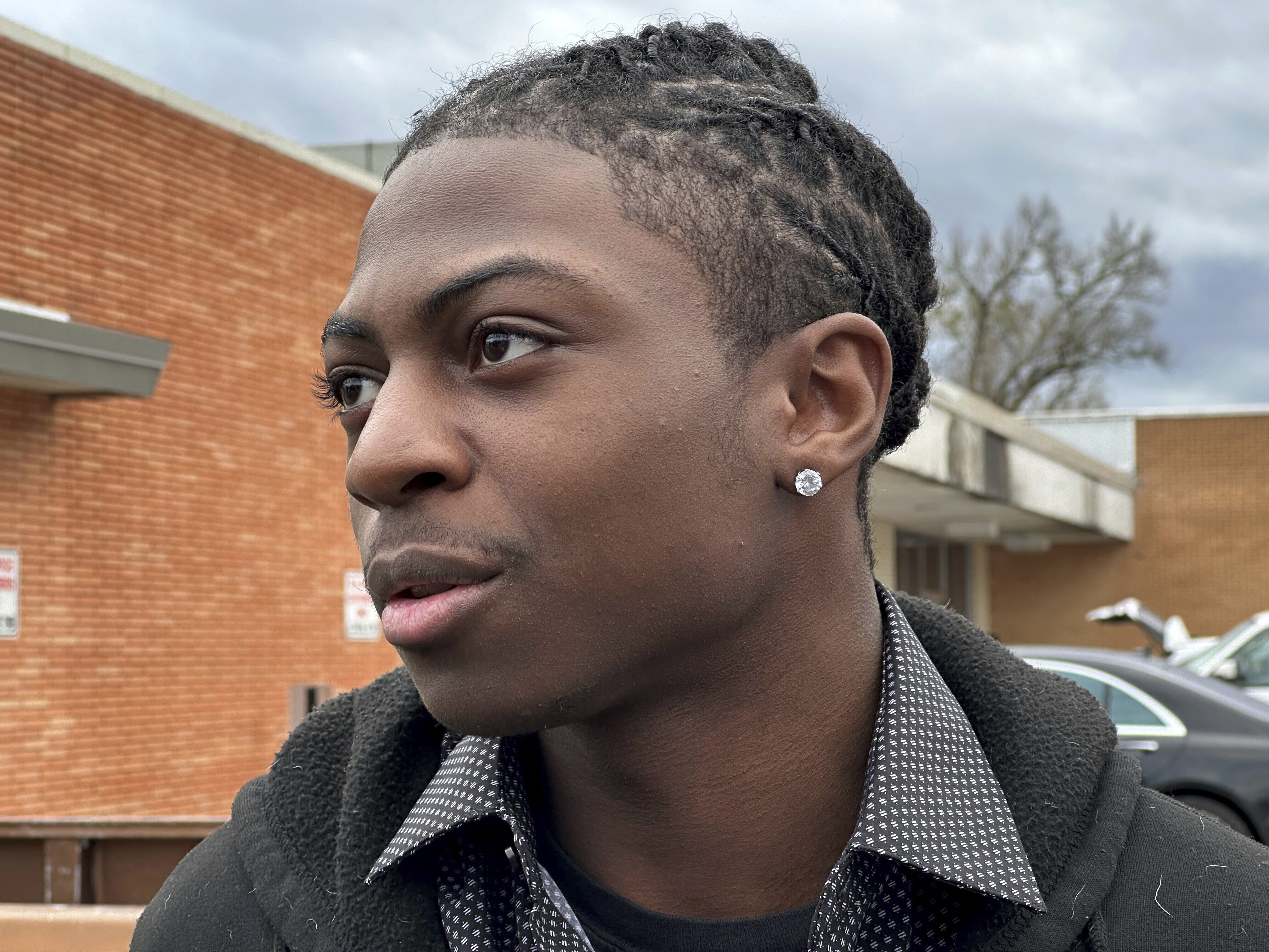 Darryl George, an 18-year-old high school junior, stands outside a courthouse in Anahuac, Texas, on Wednesday. A judge ordered Wednesday that a trial be held next month to determine whether George can continue being punished by his district for refusing to change a hairstyle he and his family say is protected by a new state law. 