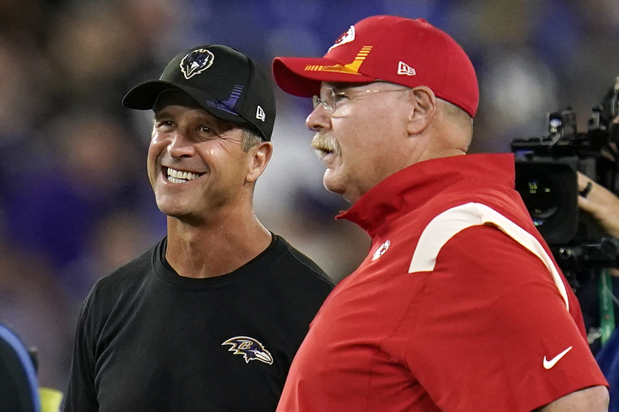 FILE - Baltimore Ravens head coach John Harbaugh, second from left, and Kansas City Chiefs head coach Andy Reid chat before an NFL football game, Sunday, Sept. 19, 2021, in Baltimore. Harbaugh once beat his own brother to win the Super Bowl, so facing a mentor probably won't rattle him. Still, there's plenty of appreciation between the Baltimore coach and Andy Reid, his counterpart on the Kansas City sideline for this week's AFC championship game. 
