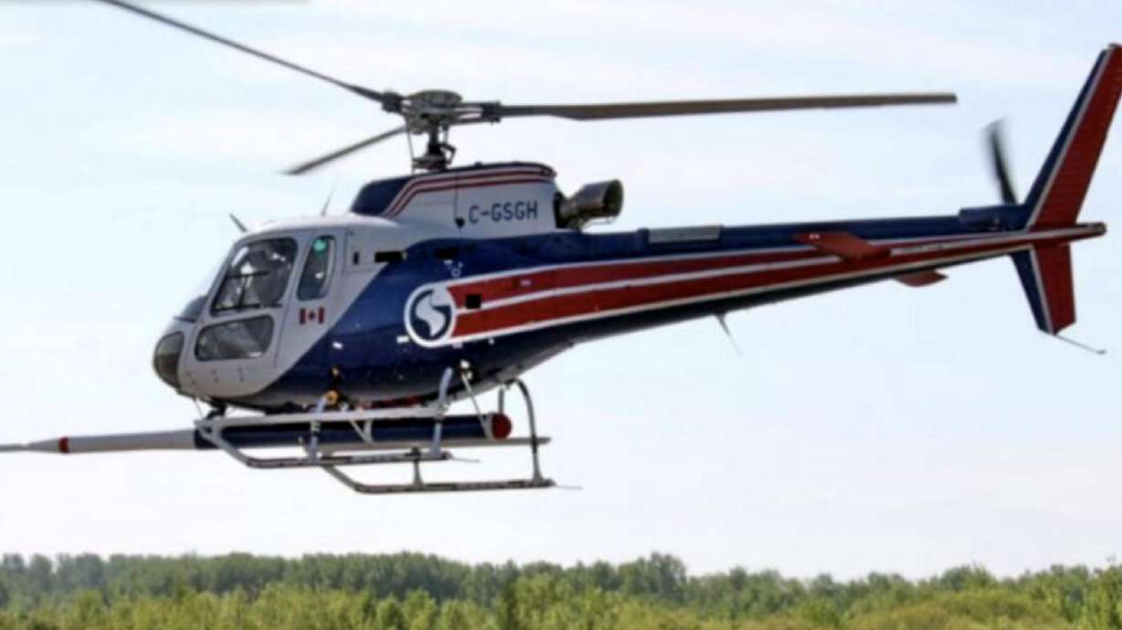 A helicopter with a forward facing stinger magnetometer flies about the ground, location not specified, Oct. 10, 2022. Its stinger-like front has some members of the community asking questions.