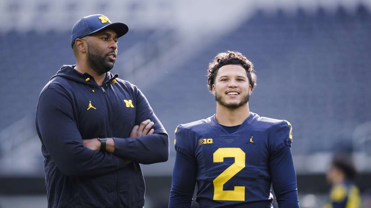 Michigan offensive coordinator Sherrone Moore, left, speaks with running back Blake Corum during NCAA college football practice Saturday, Dec. 30, 2023, in Inglewood, Calif. Alabama is scheduled to play against Michigan on New Year's Day in the Rose Bowl, a semifinal in the College Football Playoff.