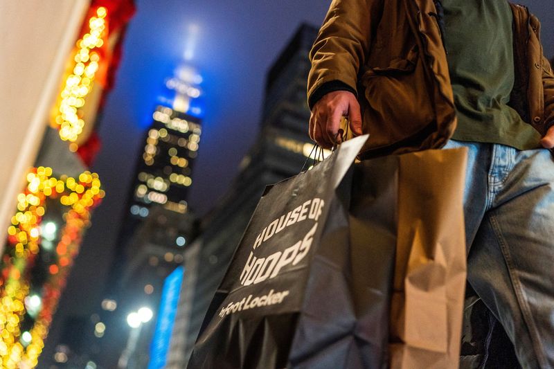 A man carries his shopping bags during the holiday season in New York City, Dec. 10, 2023. A new report shows the economy grew faster than expected in the fourth quarter.
