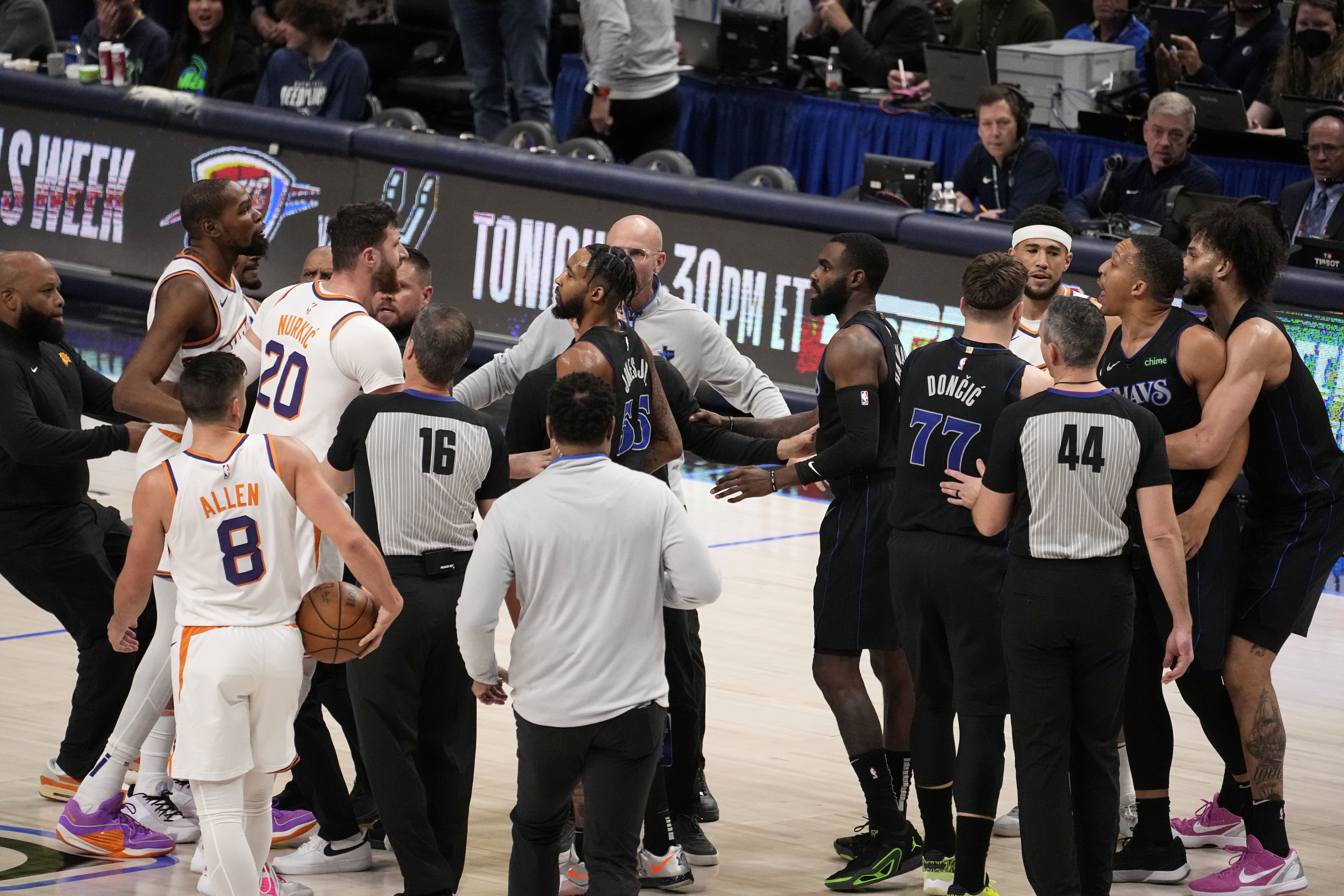 Team staff, players and officials run onto the court after an on court incident between Phoenix Suns' Kevin Durant, second from top left, and Dallas Mavericks' Grant Williams, second from top right, in the first half of an NBA basketball game in Dallas, Wednesday, Jan. 24, 2024. 