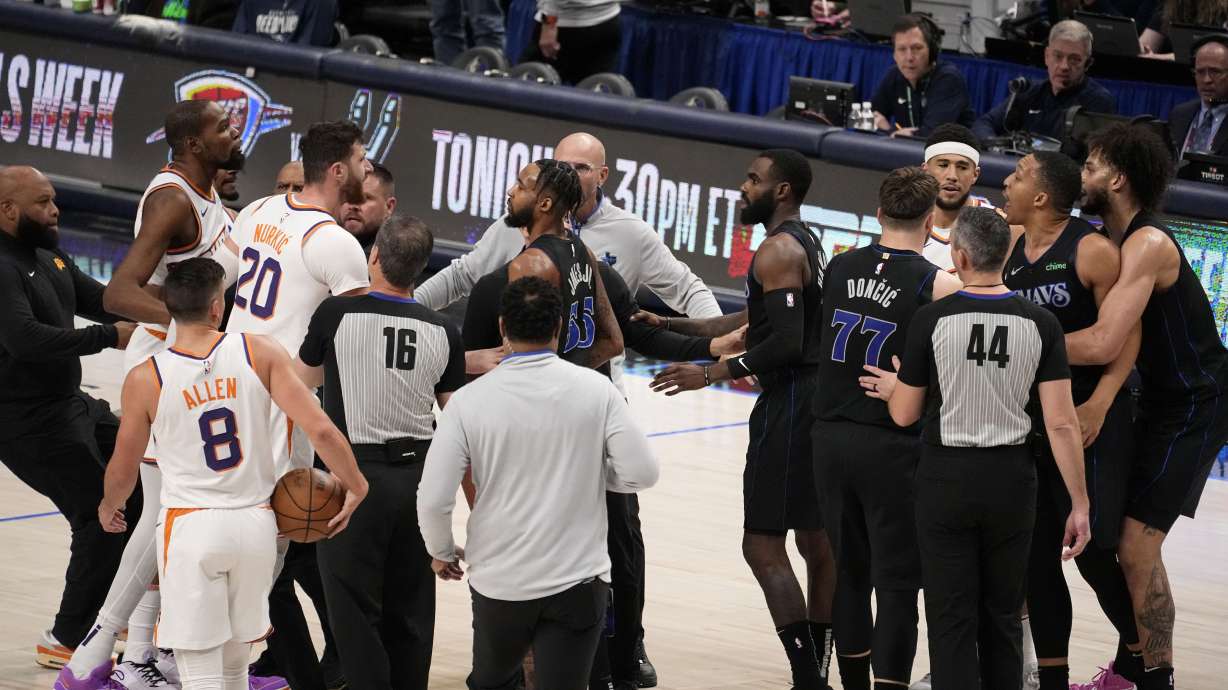 Team staff, players and officials run onto the court after an on court incident between Phoenix Suns' Kevin Durant, second from top left, and Dallas Mavericks' Grant Williams, second from top right, in the first half of an NBA basketball game in Dallas, Wednesday, Jan. 24, 2024.
