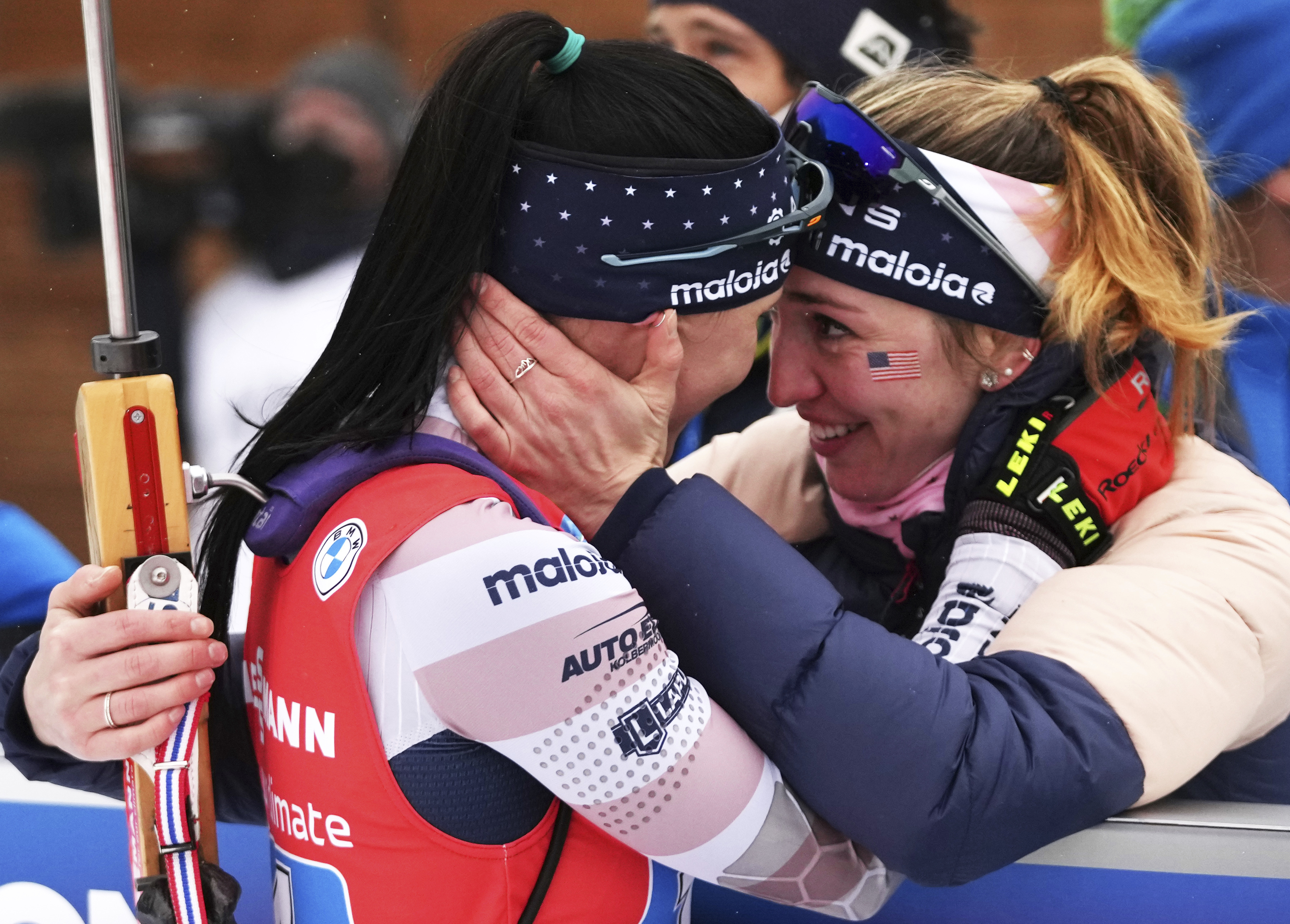 FILE - Joanne Reid, left, of United States, and compatriot Deedra Irwin embrace at the finish line during the women's 4 x 6 km relay race at the biathlon World Cup in Anterselva, Italy, Jan. 22, 2022. The United States Biathlon national champion was sexually harassed and abused for years by a ski-wax technician while racing on the sport's elite World Cup circuit, investigators found. When the two-time Olympian complained, Reid said she was told his behavior was just part of the male European culture. 