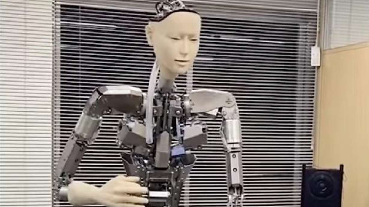 A humanoid robot powered by artificial intelligence responds to text commands, including playing a guitar, laughing and dancing.